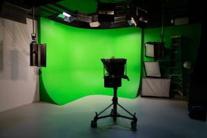 A picture of the opposite side of the production studio showing a chroma key green wall and camera.